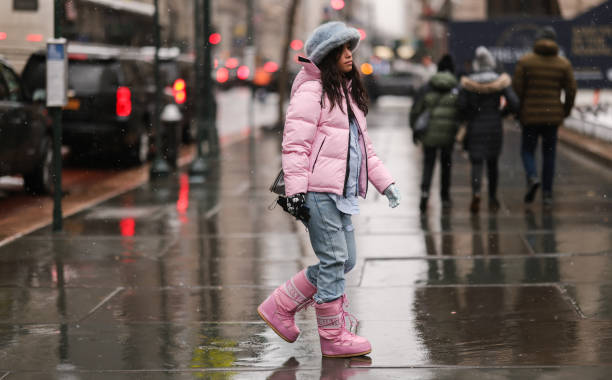 Guest wears a pale gray blue oversized fluffy hat, a pale pink hoodie puffer jacket, a baby blue shirt, blue faded denim large jeans ripped pants, a...