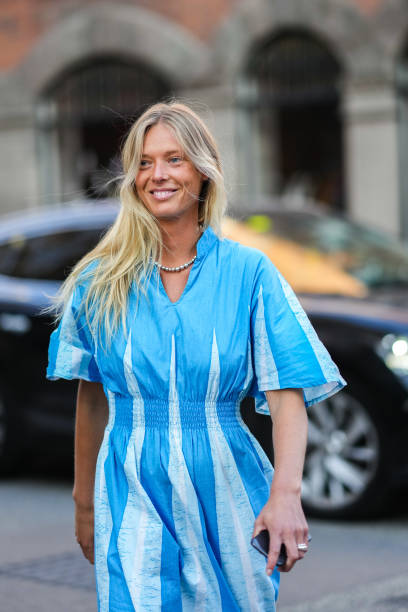 Guest wears a silver pearls necklace, a blue and pale blue print pattern / flared short sleeves / long dress, silver rings, outside Baum und...