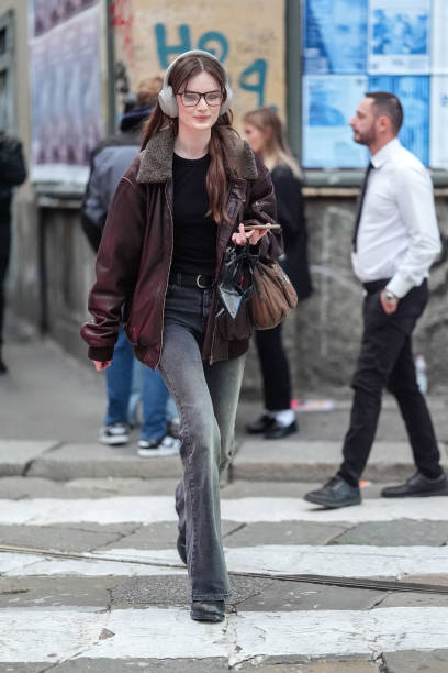 Guest wears black glasses, black t-shirt, black leather belt, washed black denim jean skinny pants, black dark brown fluffy collar oversized leather...