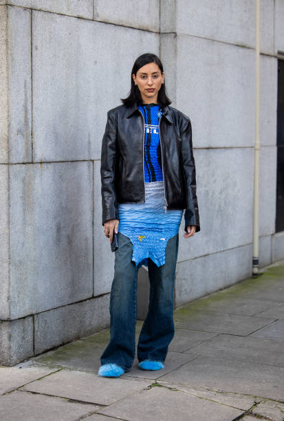 Guest wears black leather jacket, blue Inter Milan shirt, dress outside Conner Ives during London Fashion Week February 2024 on February 18, 2024 in...