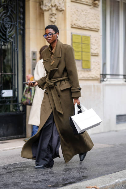 Guest wears black sunglasses, dark brown buttoned up long sleeve shirt, dark green oversized YSL blazer coat, black pants, shiny black heeled leather...