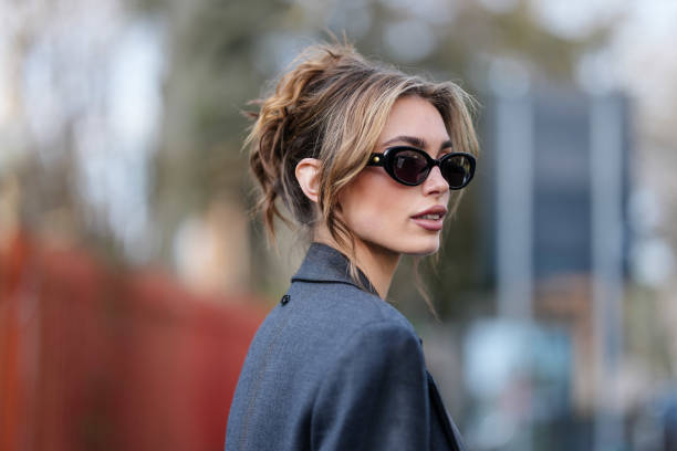 Guest wears black sunglasses, dark gray blazer coat, outside Diesel, during the Milan Fashion week Women's Fall/Winter 2025-2026 on February 26, 2025...