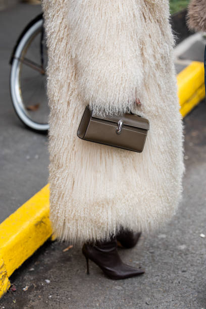 Guest wears brown bag outside Anna Sui during New York Fashion Week on February 08, 2025 in New York City.
