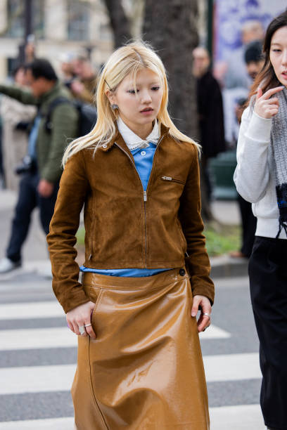 Guest wears brown suede jacket, vinyl skirt, blue blouse outside Miu Miu during the Womenswear Fall/Winter 2025/2026 as part of Paris Fashion Week on...