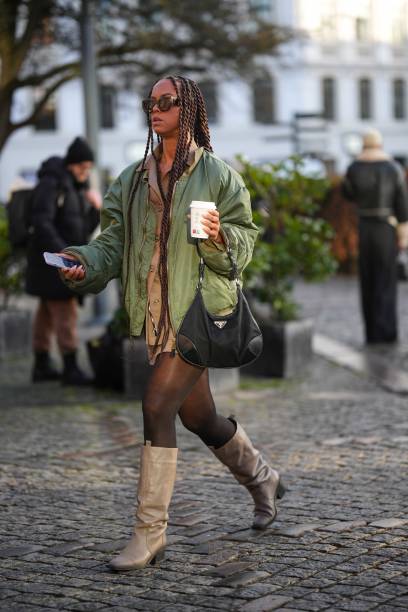 Guest wears brown sunglasses, gold chains pendant necklaces, a brown shirt from Munthe, a green oversized bomber coat, a black nylon handbag from...