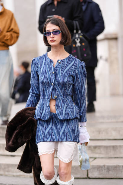 Guest wears dark brown bob hair, dark blue sunglasses, navy blue pattern knit buttoned cardigan jacket, navy blue pattern knit mini skirt, white long...