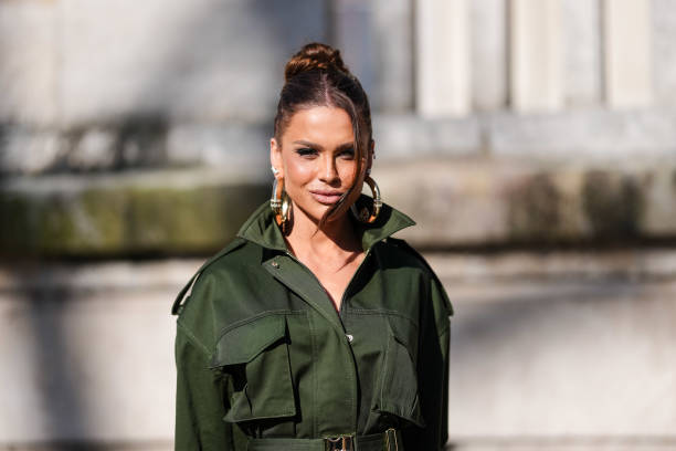 Guest wears gold earrings, dark green belted cargo Elie Saab jacket, outside Elie Saab, during the Paris Fashion week Women's Fall/Winter 2025-2026...