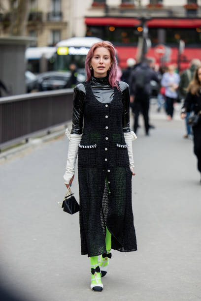 Guest wears green black button up transparent dress, neon green tights, black bag outside Chanel during the Womenswear Fall/Winter 2024/2025 as part...