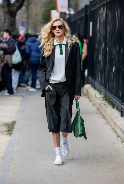 Guest wears green shorts, blazer, bag outside Lacoste during the Womenswear Fall/Winter 2025/2026 as part of Paris Fashion Week on March 09, 2025 in...