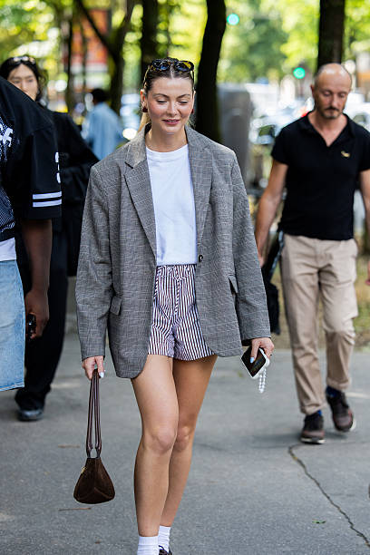 Guest wears grey oversized blazer, striped shorts, white shirt outside Issey Miyake during the Menswear Spring/Summer 2026 shows as part of Paris...