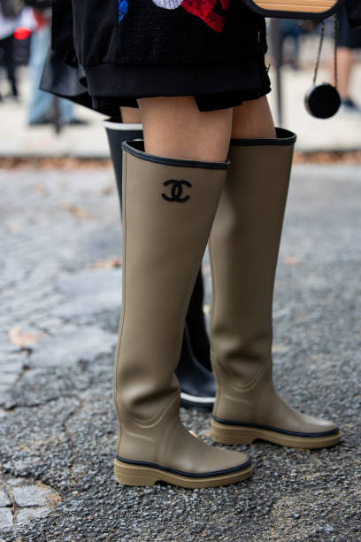 Guest wears khaki gumboots outside Chanel during the Womenswear Spring/Summer 2024 as part of Paris Fashion Week on October 03, 2023 in Paris, France.