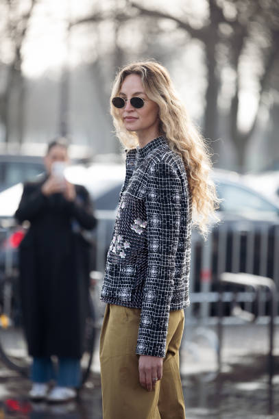Guest wears khaki pants and white and black tweed jacket outside the Chanel fashion show during the Womenswear Fall/WinterV 2025/2026 as part of...
