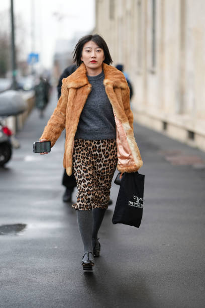 Guest wears light brown fuzzy faux fur coat, dark gray sweater, dark brown leopard pattern/print midi skirt, dark gray tights, shiny black platform...