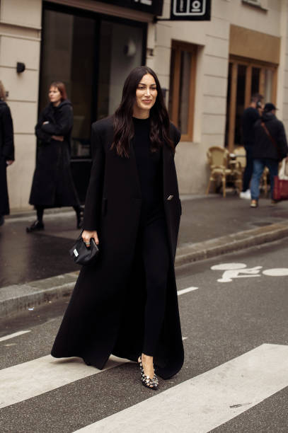 Guest wears long balck coat and black mini bag outside Chloe during the Womenswear Fall/Winter 2024/2025 as part of Paris Fashion Week on February...