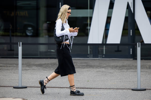 Guest wears navy blazer, Miu Miu bag, knee high socks outside Lueder during the Berlin Fashion Week SS25 on July 01, 2024 in Berlin, Germany.