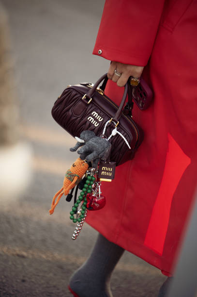 Guest wears red coat and brown Miu Miu bag with accessories during the 10th season of the Visa Fashion Week Almaty on October 18, 2024 in Almaty,...
