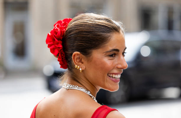 Guest wears red dress, necklace, red hair band outside Gestuz during day four of the Copenhagen Fashion Week SS25 on August 08, 2024 in Copenhagen,...