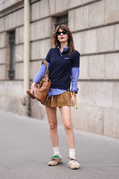 Guest wears sunglasses,a navy blue polo shirt, a blue shirt with printed checkered / checked pattern, a large brown leather bag, a Miu Miu gathered...