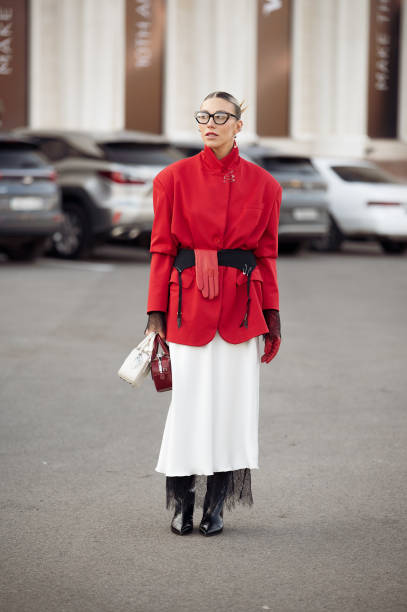 Guest wears white long skirt, red jacket, long black boots, white and red bags, black belt and one red glove during the 10th season of the Visa...