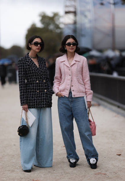 Guests are seen outside Chanel show wearing black Chanel sunnies, rose tweed Chanel jacket, black and white checkered tweed Chanel blazer, oversized...