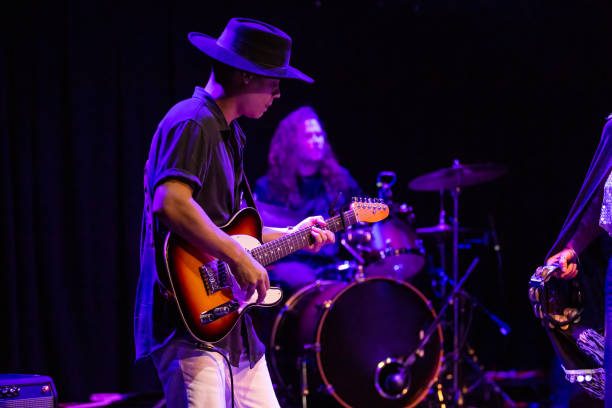 guitarist wearing wide brimmed hat performing onstage with band - concert stock pictures, royalty-free photos & images