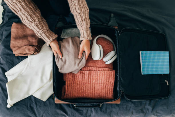 hände einer anonymen frau packen ihren koffer für den winterurlaub, eine overhead-ansicht - travel stock-fotos und bilder