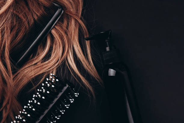 hairbrush and hair comb in long hair near styling foam. - hairstyle stockfoto's en -beelden