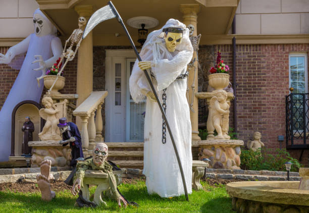 halloween decoration with grim reaper holding scythe in front of a house in brooklyn, new york, usa. - garden decoration stock pictures, royalty-free photos & images