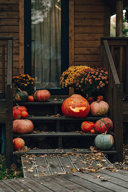halloween jack-o'-lantern and pumpkins decorating a wooden porch - garden decoration stock pictures, royalty-free photos & images