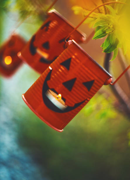 halloween jack o'lantern with candles hanging in tree at dusk - garden decoration stock pictures, royalty-free photos & images