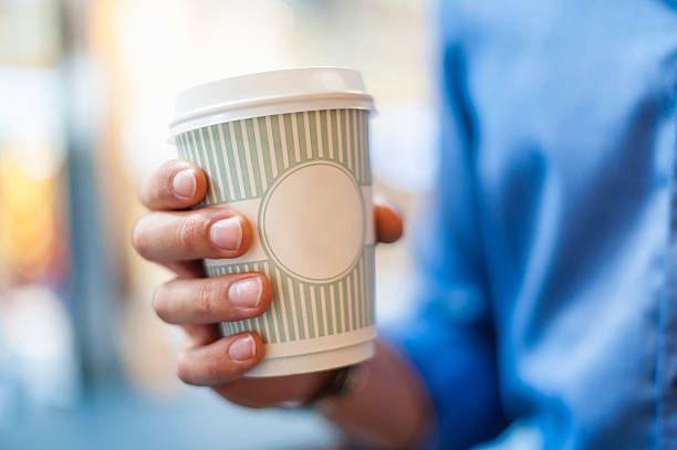 hand holding takeaway coffee - junk food stock pictures, royalty-free photos & images