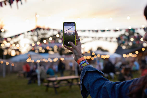 hand of woman photographing bunting through phone - concert stock pictures, royalty-free photos & images