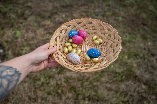 hands holding basket with chocolate eggs - garden decoration stock pictures, royalty-free photos & images