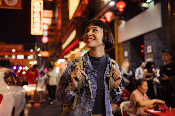 happy asian tourist enjoying on the city street at night. - travel stock pictures, royalty-free photos & images