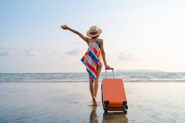 happy asian woman with sunhat enjoy travel on the beach in summer - travel stock pictures, royalty-free photos & images