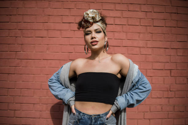 happy beautiful fashion hipster young woman smiling while posing in front of red brick wall - hairstyle stock pictures, royalty-free photos & images