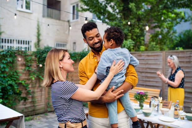 happy biracial family with small son during family dinner outdoors in garden. - garden decoration photos et images de collection