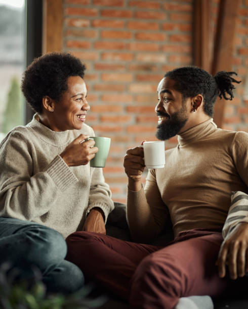 happy black couple talking during tea time at home. - coffee stockfoto's en -beelden