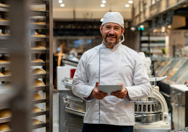 happy business owner managing a bakery and using a digital tablet - food stock pictures, royalty-free photos & images