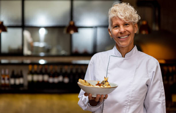 happy chef holding a plate at a fine dining restaurant - food stock pictures, royalty-free photos & images