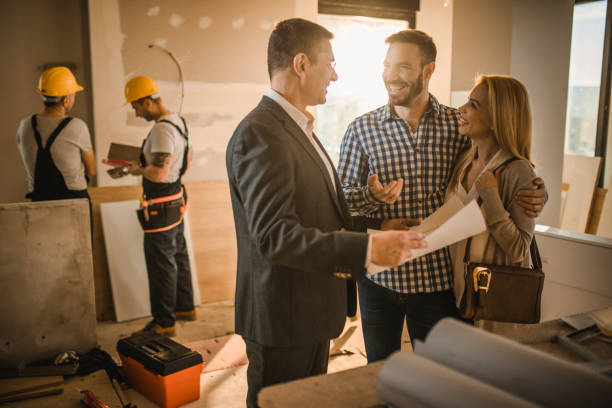 happy couple and building contractor talking about housing plan at construction site. - home decoration stock pictures, royalty-free photos & images