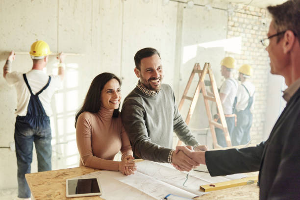 happy couple came to an agreement with agent at construction site. - home decoration stock pictures, royalty-free photos & images