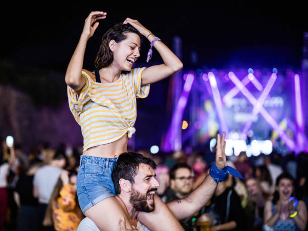 happy couple having fun on a music festival by night. - concert stock pictures, royalty-free photos & images