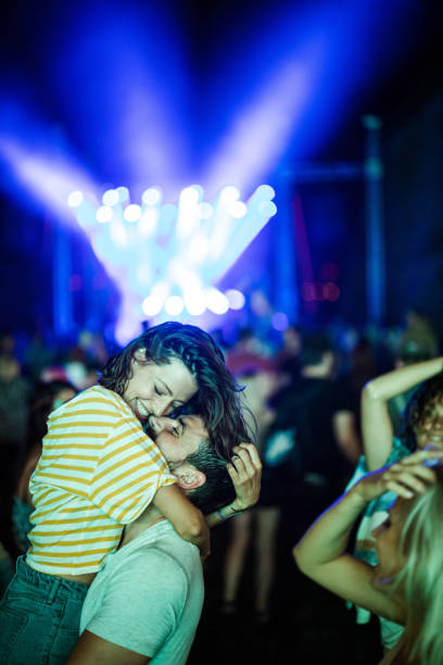 happy couple in love having fun during music festival by night. - concert stock pictures, royalty-free photos & images