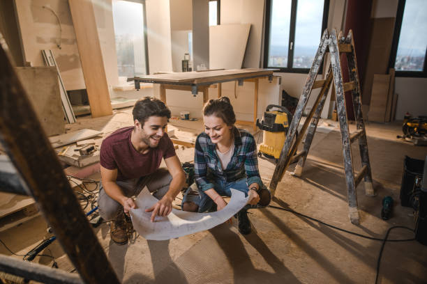 happy couple looking at their housing project on construction site. - home decoration stock pictures, royalty-free photos & images