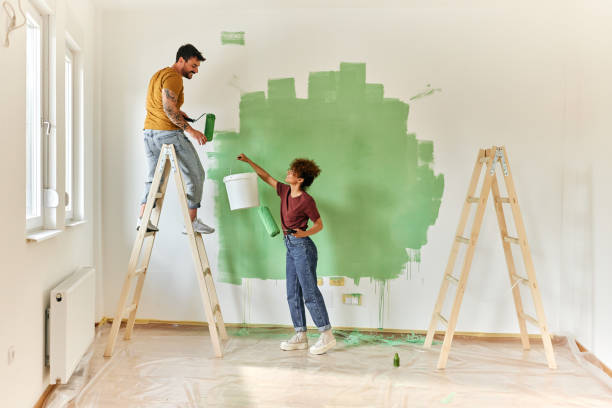 happy couple painting their new apartment. - home decoration stock pictures, royalty-free photos & images