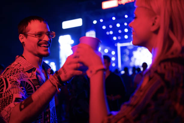 happy couple toasting during a music concert at night. - concert stock pictures, royalty-free photos & images