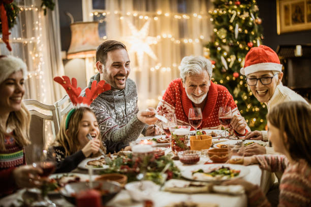 happy extended family having new year's lunch at dining table. - food stock pictures, royalty-free photos & images