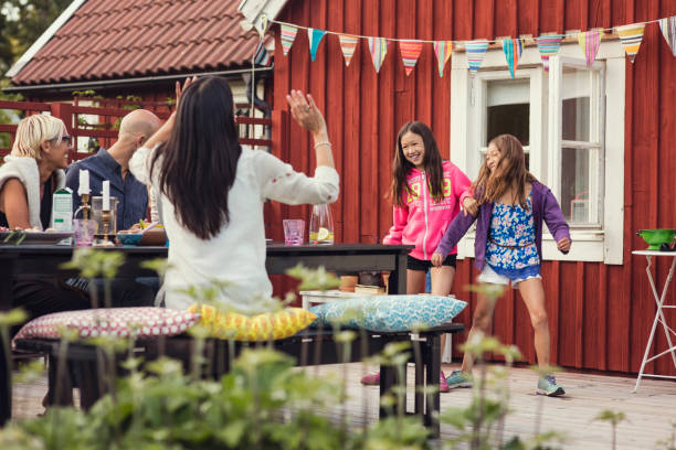 happy family and friends watching girls dancing in back yard during garden party - garden decoration stock pictures, royalty-free photos & images