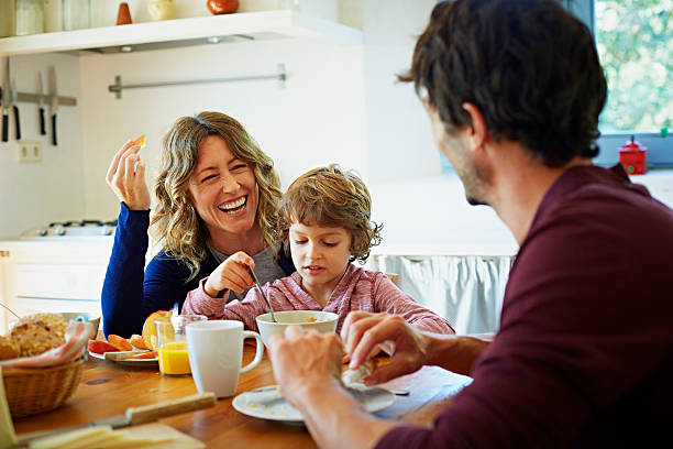 happy family enjoying breakfast at table - food stockfoto's en -beelden